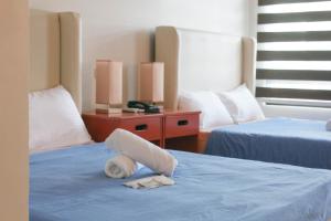 a towel laying on top of a bed at Grand Emilia Hotel in Cebu City