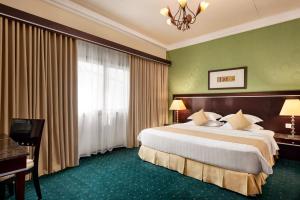 a hotel room with a large bed and a window at Eastyard Dammam Hotel in Dammam