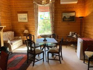 a dining room with a table and chairs and a couch at Winterbrook House in Ulverstone