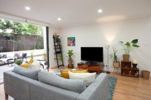 a living room with a couch and a flat screen tv at Huge 3 Bed Camperdown Garden Apt w Parking Aircon in Sydney