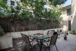 a patio with a table and chairs and a couch at Huge 3 Bed Camperdown Garden Apt w Parking Aircon in Sydney