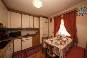 una cucina con tavolo e tovaglia; di Azalea - Happy rentals a Livigno