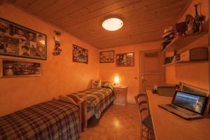 a bedroom with a bed and a desk with a laptop at Azalea - Happy rentals in Livigno