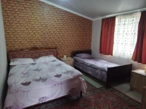 a bedroom with two beds and a brick wall at Getap in Bjni in Bjni