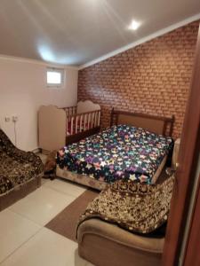 a bedroom with two beds and a brick wall at Getap in Bjni in Bjni
