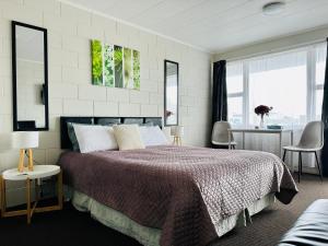 1 dormitorio con 1 cama grande y 2 sillas en A1 Kaikoura Motel & Holiday Park, en Kaikoura