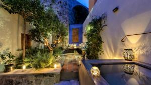 a garden with a bathtub with candles and plants at Kókkini Porta Rossa in Rhodes Town