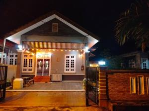 una pequeña casa con luces encendidas por la noche en Rumah Tamu Firdaus, en Marang
