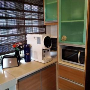 eine Küche mit einer Arbeitsplatte und einer Mikrowelle in der Unterkunft Rumah Tamu Firdaus in Marang