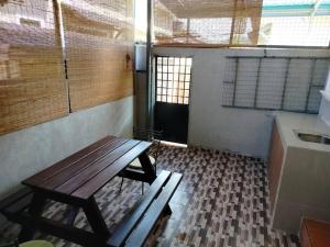 an empty room with a wooden table and a kitchen at Rumah Tamu Firdaus in Marang