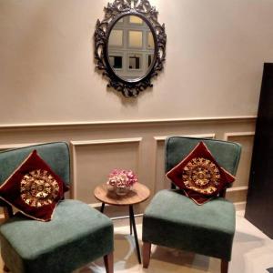 een kamer met 2 stoelen, een spiegel en een tafel bij Rumah Tamu Firdaus in Marang