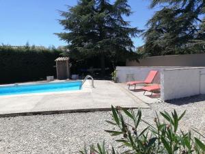 einen Pool mit einem Stuhl neben einem Zaun in der Unterkunft Maison avec SPA et Piscine in Mazan