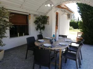 einen Tisch und Stühle auf einer Terrasse in der Unterkunft Maison avec SPA et Piscine in Mazan