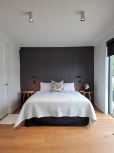 a bedroom with a large bed and two tables at Pisa House Lakefront Boutique B&B in Cromwell