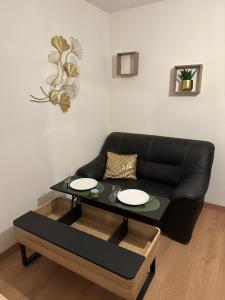 - un salon avec un canapé noir et une table dans l'établissement Appart 500 m centre ville - gare, à Soissons
