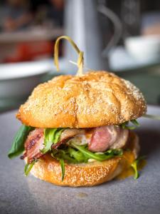 a sandwich with meat and lettuce on a bun at Pisa House Lakefront Boutique B&B in Cromwell