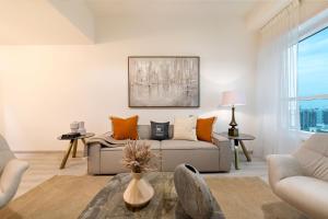 ein Wohnzimmer mit einem Sofa und einem Tisch in der Unterkunft Maison Privee - Millennium Executive Tower in Dubai