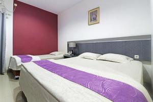 dos camas sentadas una al lado de la otra en un dormitorio en Paus Guest House Pekanbaru, en Pekanbaru