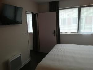 um quarto com uma cama e uma televisão de ecrã plano em Atao Residence- Rennes Sud em Vern-sur-Seiche
