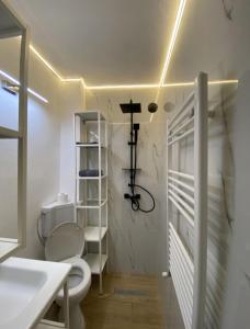 a bathroom with a toilet and a cross on the wall at Studio 100G in Târgovişte