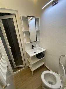 a bathroom with a white toilet and a sink at Studio 100G in Târgovişte