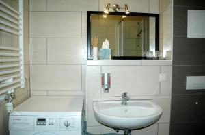 bagno bianco con lavandino e specchio di Sundappartement a Stralsund