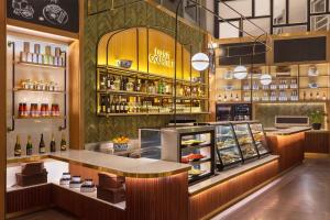 a restaurant with a counter and a shelf of food at Dusit Suites Hotel Ratchadamri, Bangkok in Bangkok +71 photos