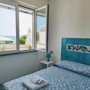 1 dormitorio con 1 cama y 2 ventanas en Domus Hormiae, en Formia