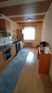 duża kuchnia z drewnianą podłogą i dużym oknem w obiekcie Apartment Monsberger w mieście Wolfsberg