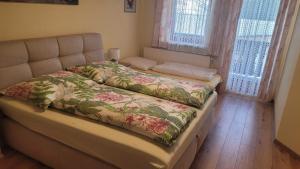 a bedroom with a bed with a floral blanket on it at Gästehaus Raab in Ranten