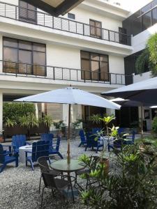 un patio con mesa, sillas y sombrilla en RedDoorz @ Occazia Hotel Pampanga en Bacolor
