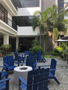 un grupo de sillas azules y una mesa frente a un edificio en RedDoorz @ Occazia Hotel Pampanga en Bacolor