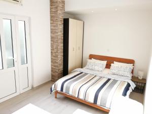 1 dormitorio con 1 cama con manta a rayas en Sea Star Kumbor, en Kumbor