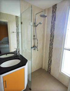 La salle de bains est pourvue d'un lavabo et d'une douche. dans l'établissement Daisy Residence, à Jomtien Beach