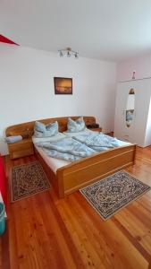 Łóżko w pokoju z drewnianą podłogą w obiekcie Apartment Monsberger w mieście Wolfsberg