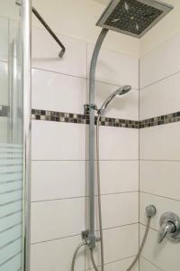 La salle de bains est pourvue d'une douche avec un pommeau de douche. dans l'établissement דיזנגוף סנטר חניה פרטית מרפסת שמש, à Tel Aviv