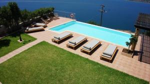 a pool with chaise lounge chairs and a swimming pool at Villa Erato - Private Pool Villa in Fársa