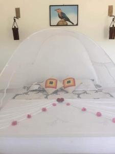 ein weißes Bett mit zwei Gläsern darüber in der Unterkunft ohm lagoon home in Tangalle