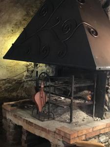 a stone fireplace with a large black stove at Gite fabuleux Saint Michel in Avapessa