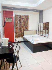 a bedroom with a bed and a table and a desk at OYO 924 Cosmo Hotel Espana Near Ust in Manila