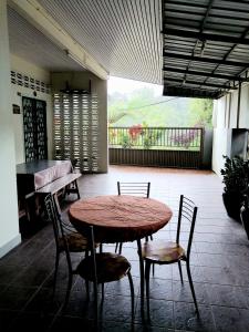 キャメロンハイランドにあるSakura Guest Houseのパティオ付きの客室で、テーブルと椅子が備わります。