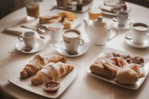 a table with plates of pastries and cups of coffee at Agriturismo Tenuta La Romana in Nizza Monferrato