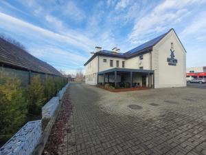 a large white building with a brick driveway at Nasz Młyn in Sufczyn