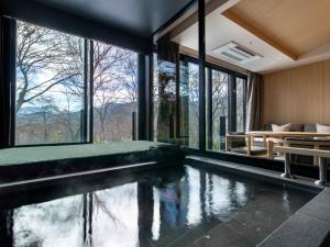 una piscina cubierta en una casa con ventanas en Fufu Hakone en Hakone