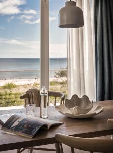 a dining room table with a view of the beach at the breeze in Ahlbeck
