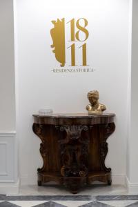 a wooden table in front of a wall with a sign at 1811 Residenza Storica in Naples