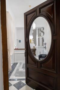 uma porta de madeira com um espelho num quarto em 1811 Residenza Storica em Nápoles