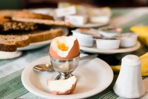 a spoon with an egg in it on a plate at Pension Westerburen in Schiermonnikoog