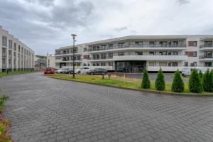 um edifício com carros estacionados num parque de estacionamento em Apartament Bryza Jantar by TriApart em Jantar