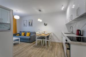 uma cozinha e sala de estar com uma mesa e um sofá em Apartament Bryza Jantar by TriApart em Jantar